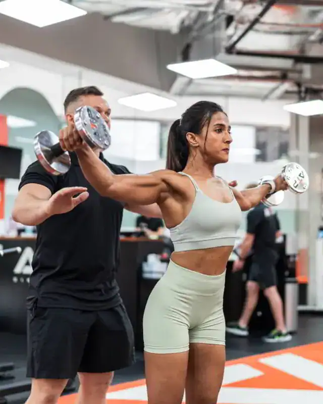 ATP client Ketki lifting dumbbells with her coach in Singapore